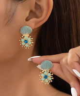 Pendientes de plata de ley azul con gemas de circonita dorada y concha