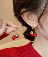 Elegantes pendientes colgantes de cerezas doradas en cobre rojo