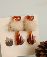 Pendientes colgantes elegantes de resina plástica naranja con bolas peludas decoradas