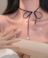 Collar con colgante de corazón de perla y lazo de encaje con cuentas de circonita negra moderna