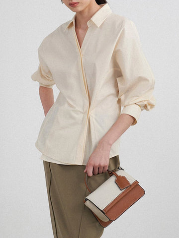 Conjunto de tres piezas de blusa y camisa de manga larga con solapa, botones sueltos, falda, pantalón y blazer con cuello con muescas. 