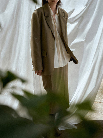 Conjunto de tres piezas de blusa y camisa de manga larga con solapa, botones sueltos, falda, pantalón y blazer con cuello con muescas. 