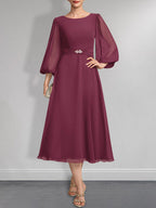 A-Linien-Chiffonkleid in Teelänge für die Mutter der Braut mit Kristallbrosche und Falten