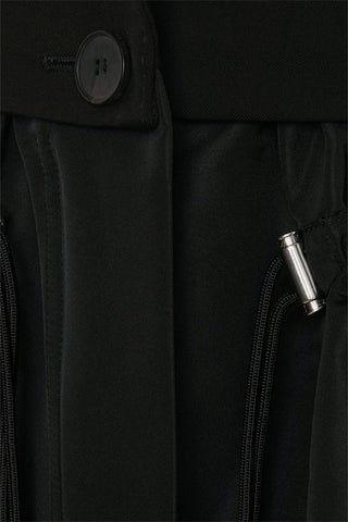 Blazer negro con dobladillo con volantes y cordón 