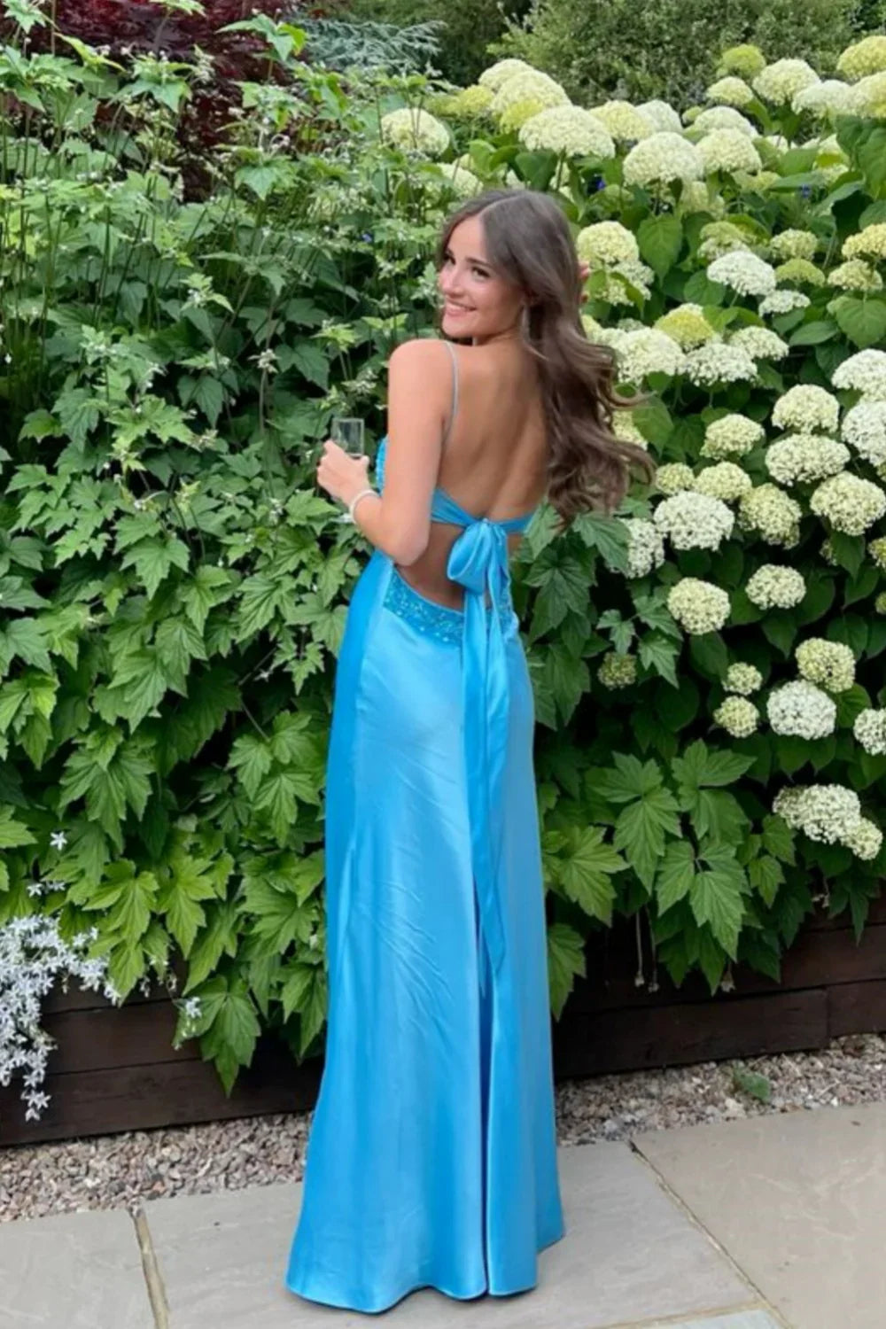 Vestido largo de corte A con cuello de pico y lazo trasero con abalorios