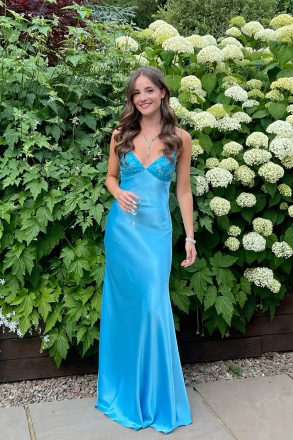 Vestido largo de corte A con cuello de pico y lazo trasero con abalorios