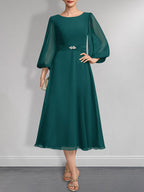 A-Linien-Chiffonkleid in Teelänge für die Mutter der Braut mit Kristallbrosche und Falten