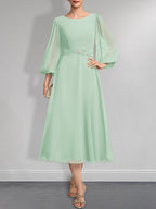A-Linien-Chiffonkleid in Teelänge für die Mutter der Braut mit Kristallbrosche und Falten