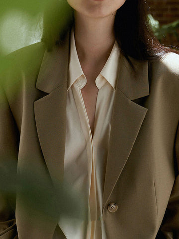 Conjunto de tres piezas de blusa y camisa de manga larga con solapa, botones sueltos, falda, pantalón y blazer con cuello con muescas. 