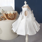 Elegantes weißes, ärmelloses, rückenfreies Faltenkleid mit Schleife für Babys – auch als Kommunionskleid für Kleinkinder geeignet. 