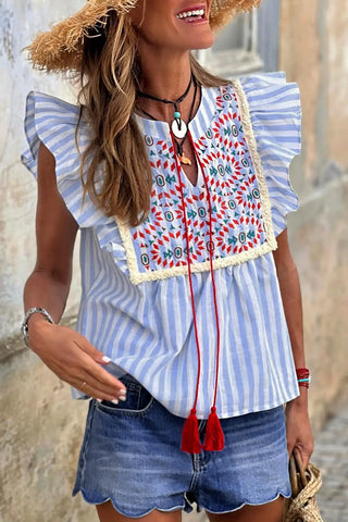 himmelblaue Bluse mit geometrischen Stickereien 