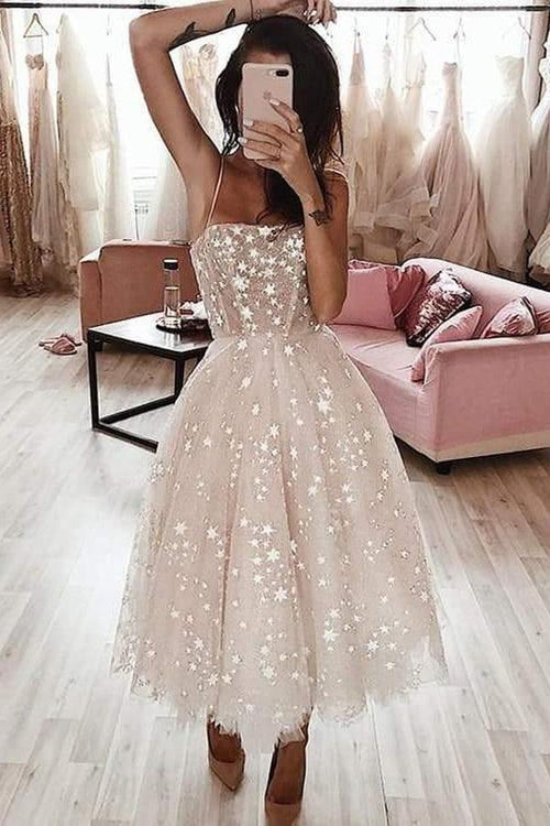 Ein A-linienförmiges, teelanges Heimkehrkleid mit Spaghettiträgern und Perlenstickerei