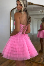 Un vestido de regreso a casa de tul sin tirantes con cuentas y corte en A