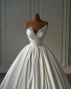 Hermoso vestido de novia largo de satén estilo princesa, corte A, color marfil y con perlas.