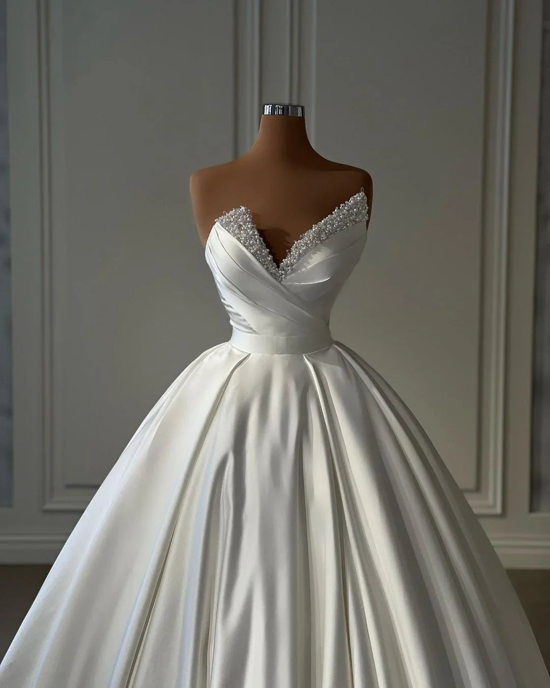 Hermoso vestido de novia largo de satén estilo princesa, corte A, color marfil y con perlas.