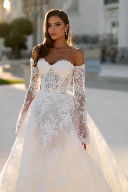 Atractivo vestido de novia largo con silueta en A, hombros descubiertos y encaje con mangas largas
