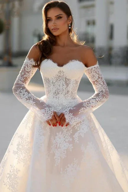 Atractivo vestido de novia largo con silueta en A, hombros descubiertos y encaje con mangas largas