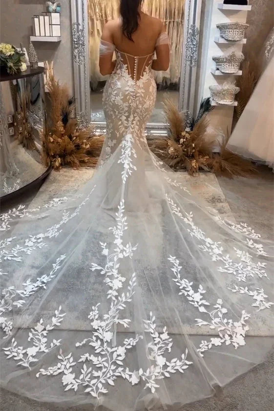 Hermoso vestido de novia largo de sirena con hombros descubiertos, apliques sin mangas y encaje