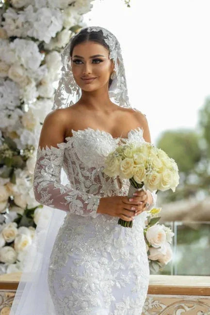 Hermoso vestido de novia largo blanco de sirena con hombros descubiertos, encaje brillante y mangas largas