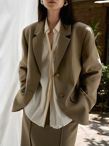 Conjunto de tres piezas de blusa y camisa de manga larga con solapa, botones sueltos, falda, pantalón y blazer con cuello con muescas. 