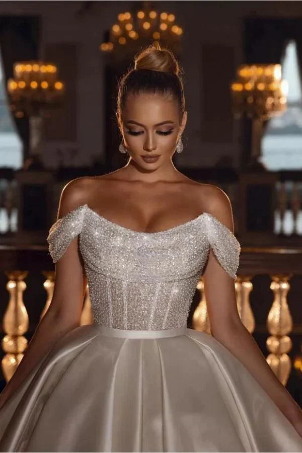 Lujoso vestido de novia largo de satén con lentejuelas brillantes y hombros descubiertos