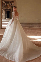 Lujoso vestido de novia largo color marfil con escote cuadrado, encaje y cuentas, y mangas largas.